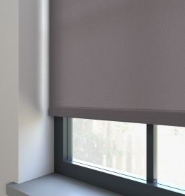A grey dimout roller blind in a window